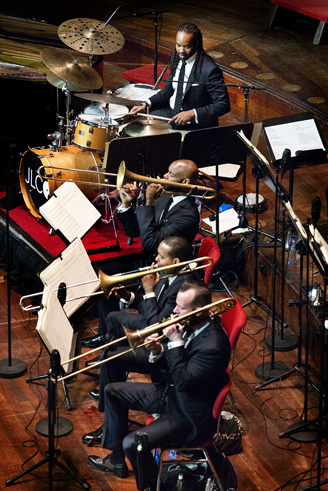 De trombonesectie van het Jazz at Lincoln Center Orchestra met op de achtergrond slagwerker Obed Calvaire. 
